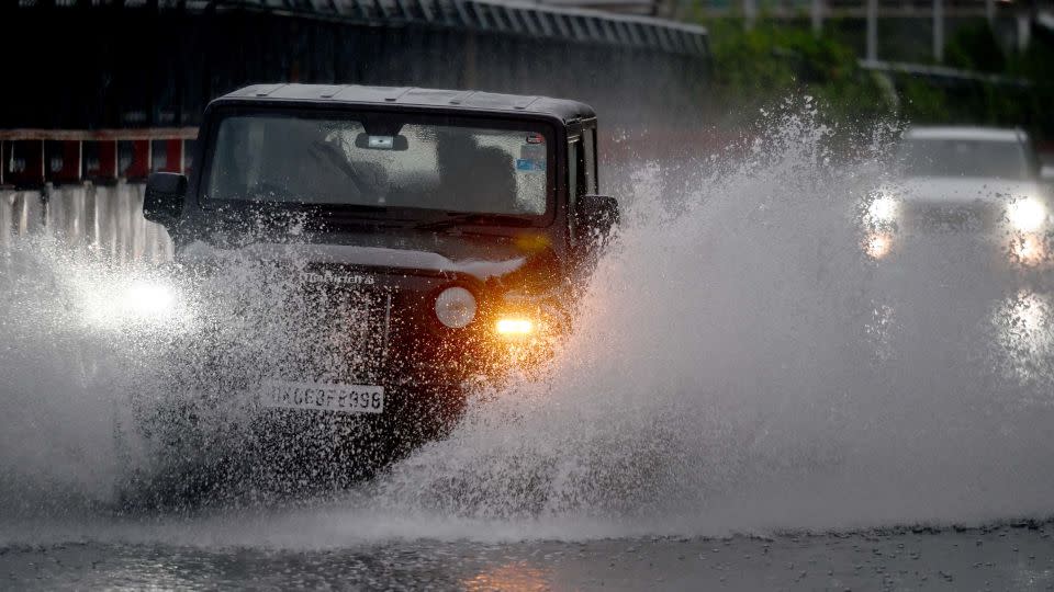 Commuters pass through a heavily waterlogged stretch of road on June 25, 2023. - Sunil Ghosh/Hindustan Times/Shutterstock