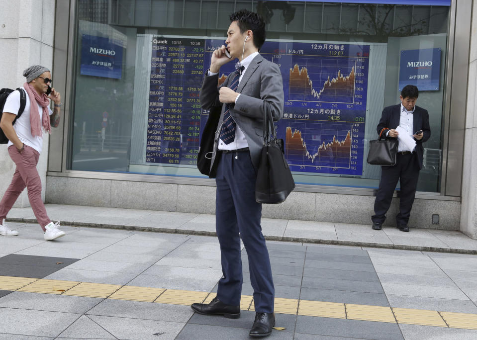 People stand in front of an electronic stock board of a securities firm in Tokyo, Thursday, Oct. 18, 2018. Shares fell Thursday in Asia after a retreat on Wall Street driven by a sell-off of technology shares, homebuilders and retailers. A report of weaker Japanese exports in September underscored uncertainties over the outlook for trade. (AP Photo/Koji Sasahara)