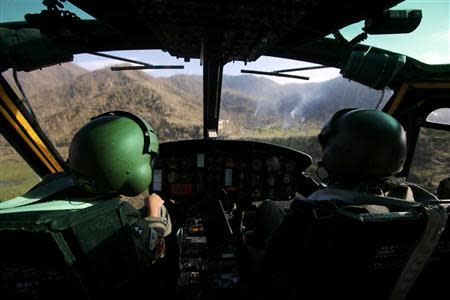 Smoke rises from campfires as a helicopter crew of the Philippine Air Force approaches a mountainous area inaccessible for vehicles, to distribute food, some 25km (17 miles) west of Tacloban city November 17, 2013. The Philippine and U.S. Air Forces are flying rice, clothes and drinking water into remote areas of the central Philippines, which are unreachable by vehicles. REUTERS/Wolfgang Rattay