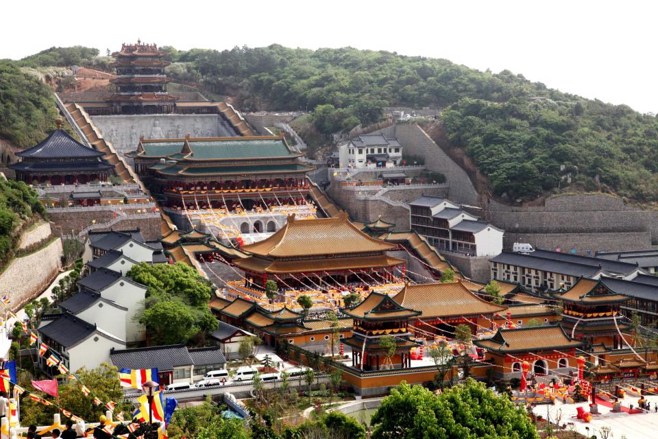 In this photo taken May 10, 2011, preparations take place to celebrate the completion of a new tower at the Baotuo Monastery in Putuo Mountains in Zhoushan city in east China's Zhejiang province. Authorities announced Monday, Oct. 22, 2012, a ban on temples selling shares to investors after leaders of several temples planned to pursue stock market listings for them as commercial entities. (AP Photo) CHINA OUT