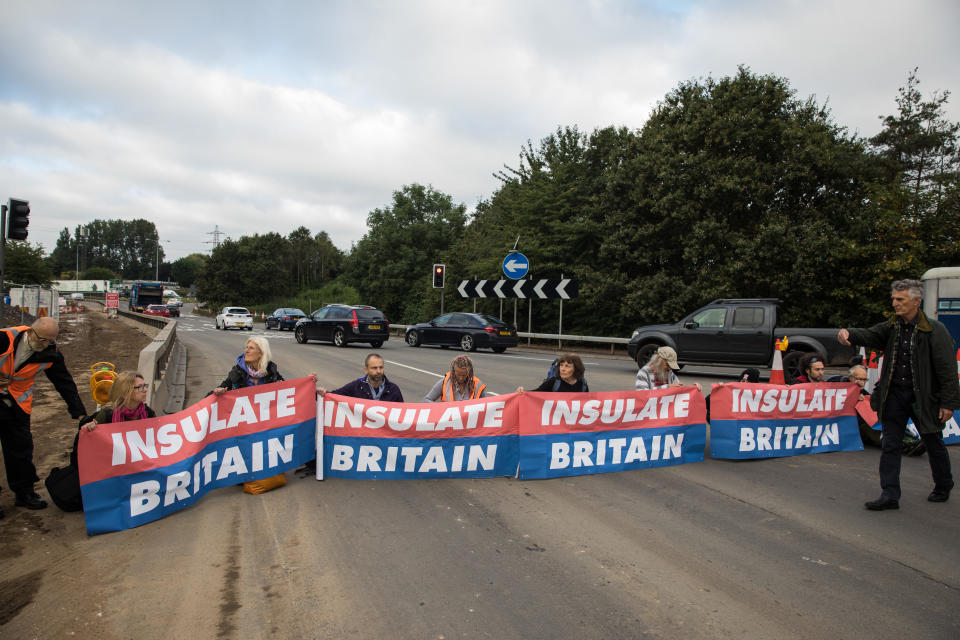 Insulate Britain climate activists block a slip road from the M25 at Junction 25 as part of a campaign intended to push the UK government to make significant legislative change to start lowering emissions on 15th September 2021 in Enfield, United Kingdom. The activists, who wrote to Prime Minister Boris Johnson on 13th August, are demanding that the government immediately promises both to fully fund and ensure the insulation of all social housing in Britain by 2025 and to produce within four months a legally binding national plan to fully fund and ensure the full low-energy and low-carbon whole-house retrofit, with no externalised costs, of all homes in Britain by 2030 as part of a just transition to full decarbonisation of all parts of society and the economy. (photo by Mark Kerrison/In Pictures via Getty Images)