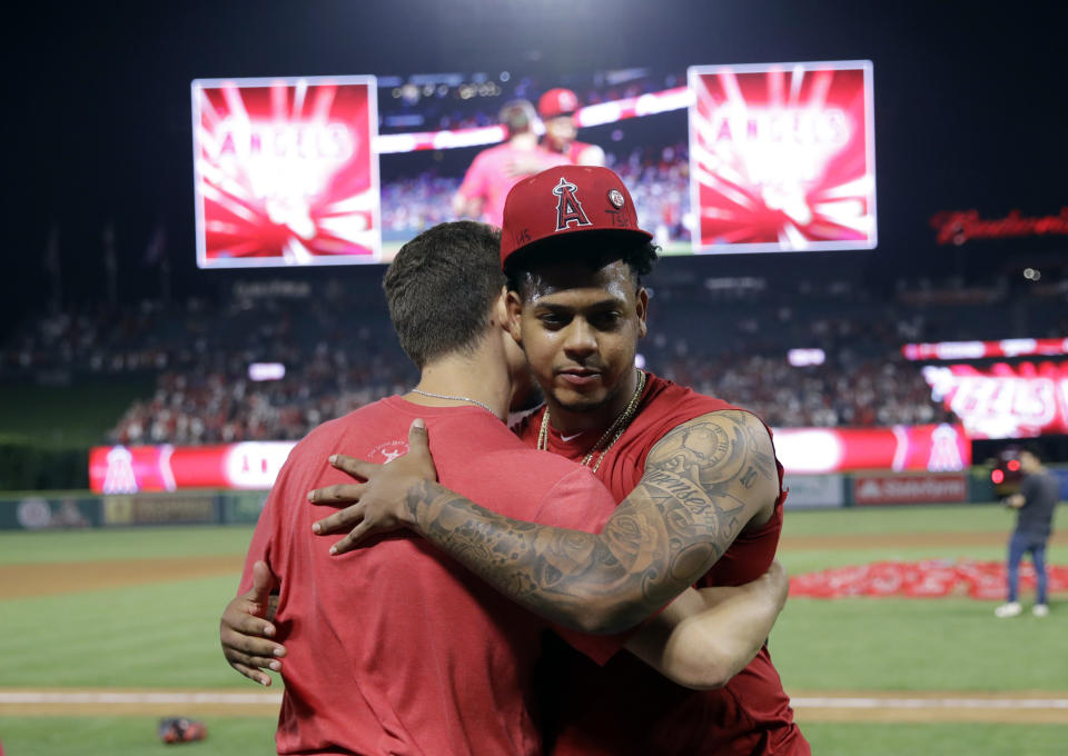 Los Angeles Angels relief pitcher Felix Pena, right, hugs starter Taylor Cole after they threw a combined-no hitter against the Seattle Mariners during a baseball game Friday, July 12, 2019, in Anaheim, Calif. The Angels won 13-0. (AP Photo/Marcio Jose Sanchez)