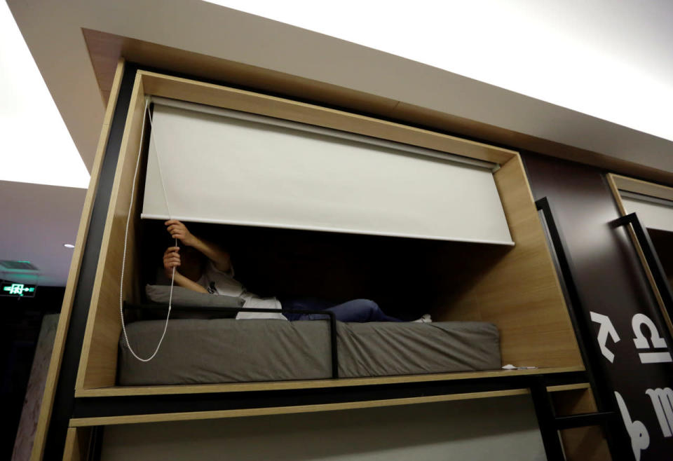Zhang Shuangjie, an IT engineer at BaishanCloud, drops the curtain as he prepares to sleep in an individual sleeping unit in the office around midnight in Beijing on April 26, 2016. (Jason Lee/Reuters)