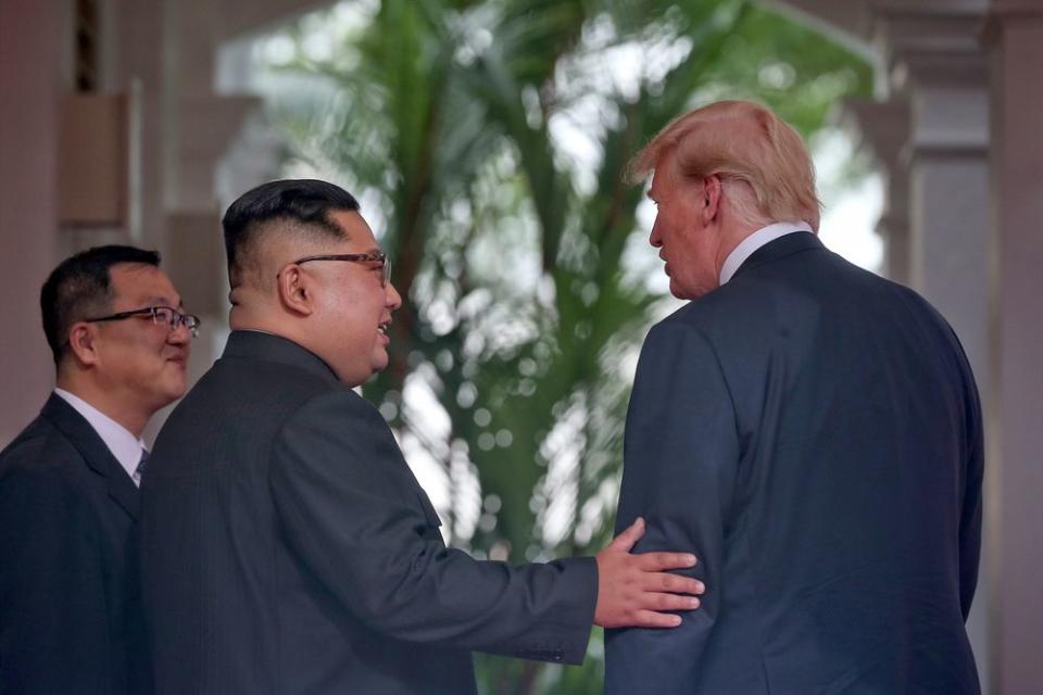 North Korean leader Kim Jong Un touches the arm of PresidentTrump shortly after meeting at their summit in Singapore on June 12, 2018.