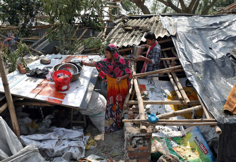 Residents salvage their belongings from the rubble of a damaged house in the aftermath of Cyclone Amphan, in South 24 Parganas district