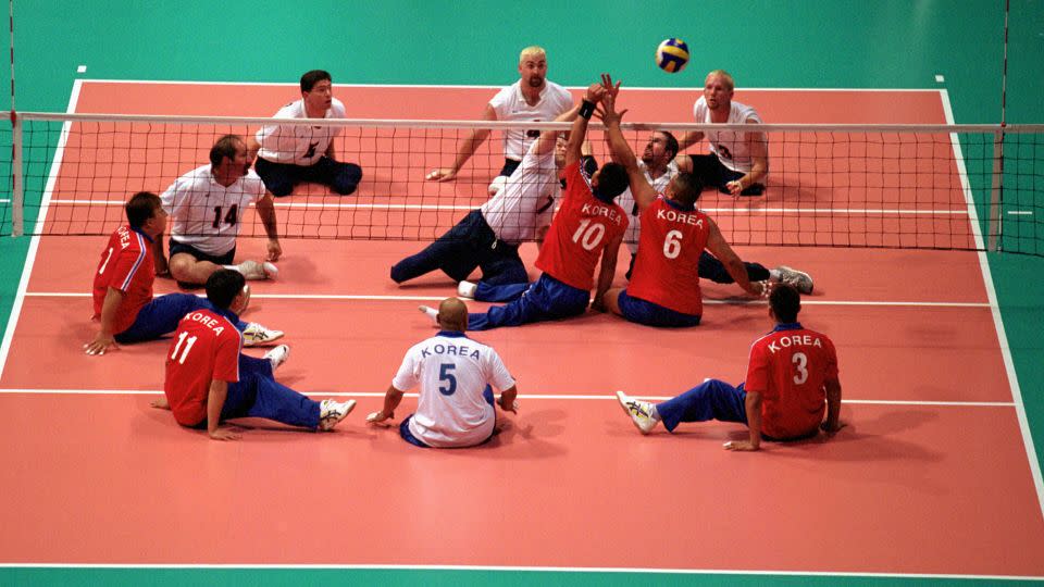 Team USA spikes the ball over the net against Team Korea in the Sydney 2000 Paralympic Games. - Adam Pretty/Getty Images