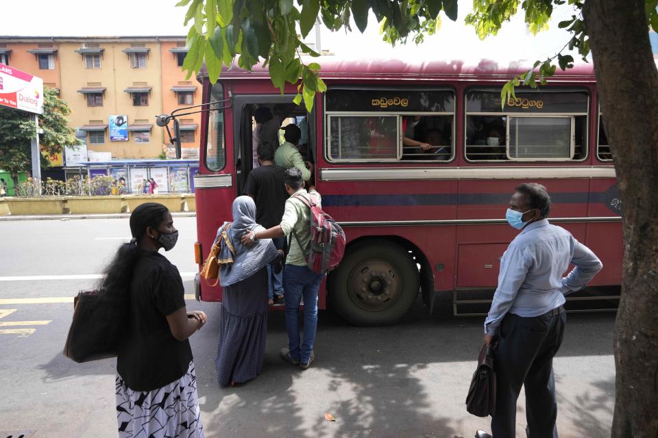 People try to get board a crowded bus amid fuel shortage in Colombo, Sri Lanka, Tuesday, July 5, 2022. Sri Lanka's ongoing negotiations with the International Monetary Fund have been complex and difficult than the instances before because it has entered talks as a bankrupt nation, the country's prime minister said Tuesday. (AP Photo/Eranga Jayawardena)