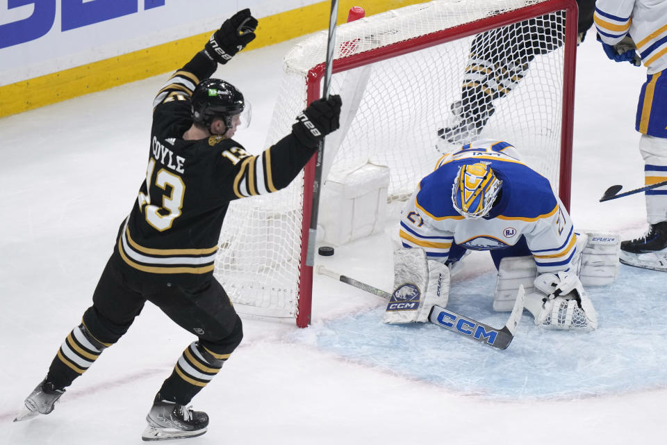 Boston Bruins center Charlie Coyle (13) celebrates as Buffalo Sabres goaltender Devon Levi (27) is unable to stop a shot by Bruins left wing Brad Marchand for a goal during the second period of an NHL hockey game Thursday, Dec. 7, 2023, in Boston. (AP Photo/Steven Senne)