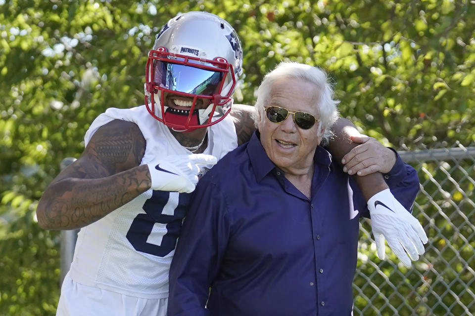 New England Patriots wide receiver Kendrick Bourne, left, puts his arm around Patriots owner Robert Kraft, right, as they step on the field at training camp at the NFL football team's practice facility, Wednesday, July 27, 2022, in Foxborough, Mass. (AP Photo/Steven Senne)