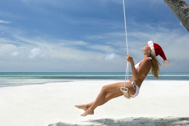 Tropical Christmas woman on a swing