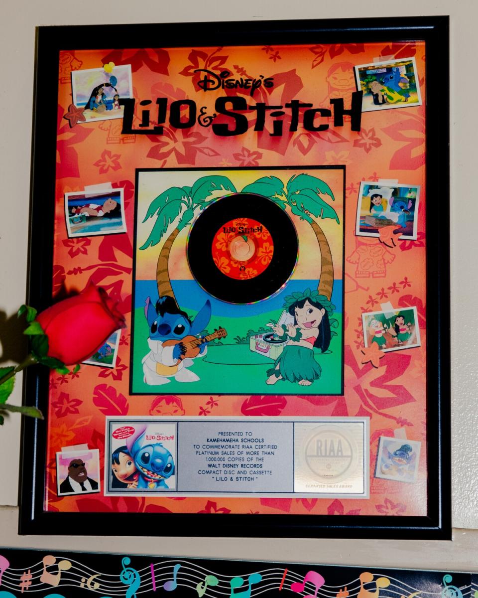 A framed plaque with a record and images from the cartoon film "Lilo & Stitch"