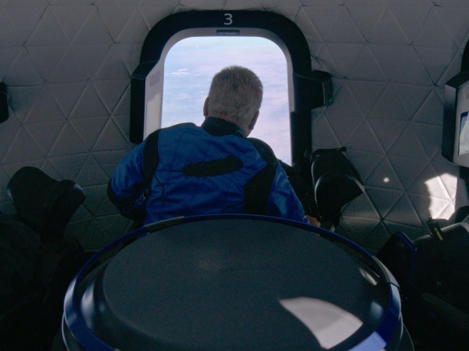 Shatner looks out a window aboard the Blue Origin space vehicle (via REUTERS)