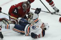 Edmonton Oilers right wing Kailer Yamamoto, right, is pulled down in front of Arizona Coyotes goaltender Antti Raanta (32) during the first period of an NHL hockey game Tuesday, Feb. 4, 2020, in Glendale, Ariz. (AP Photo/Ross D. Franklin)