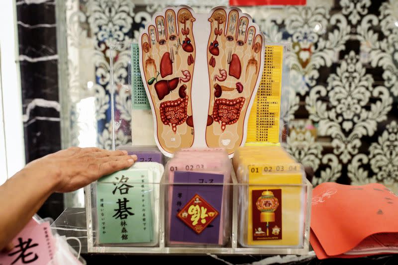 A staff shows hotel passes for drivers at a massage parlour that targets foreign tour groups in Taipei