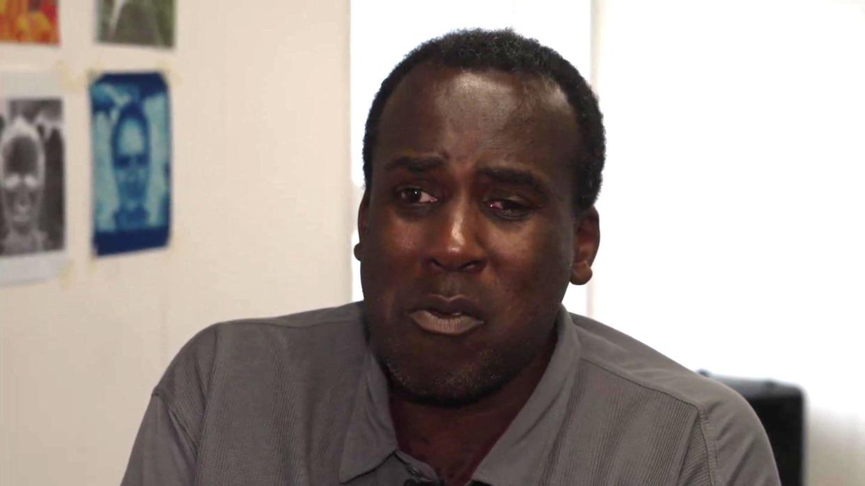 Oliver Campbell has a serious look on his face as he sits down for an interview with BBC Look East. He has short hair and is wearing a grey shirt. 