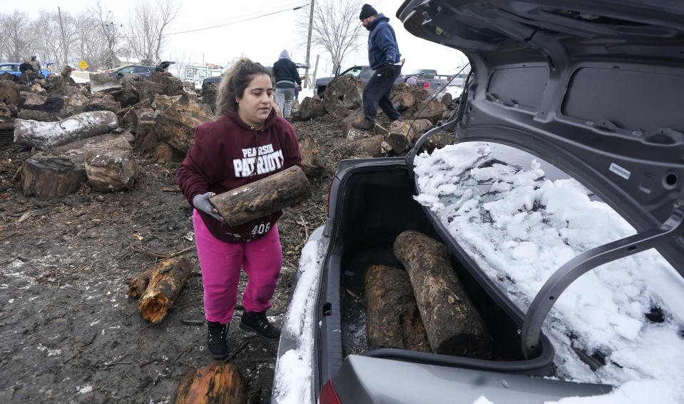 Sara Castillo loads firewood into her car Wednesday, Feb. 17, 2021, in Dallas. Castillo said the fire would be used to burn for warmth as her family has been without power since Sunday due to blackouts caused by extreme cold. (AP Photo/LM Otero)