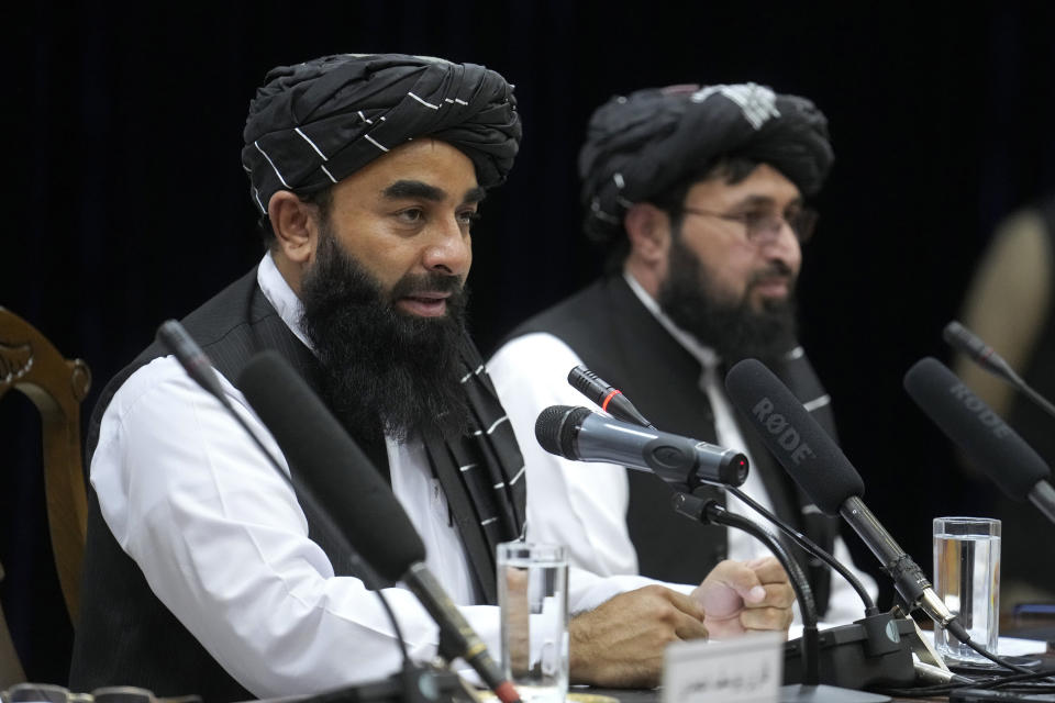 Zabiullah Mujahid, left, the spokesman for the Taliban government, speaks during a press conference in Kabul, Afghanistan, Thursday, June 30, 2022. Afghanistan's Taliban rulers held a gathering Thursday of some 3,000 Islamic clerics and tribal elders for the first time since seizing power in August, urging them to advise them on running the country. Women were not allowed to attend. (AP Photo/Ebrahim Noroozi)