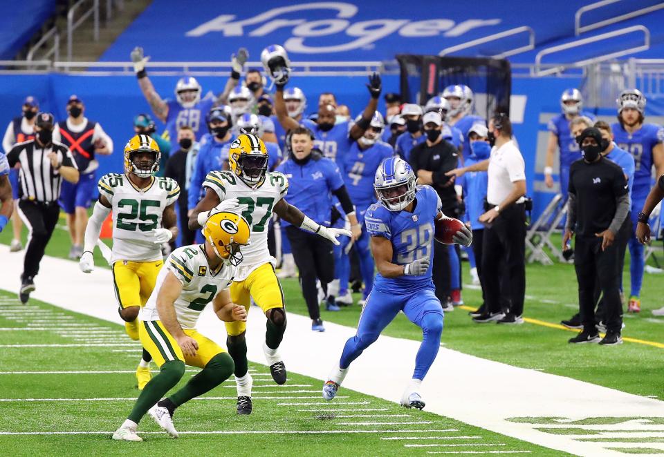Jamal Agnew (39) of the Detroit Lions returns a kickoff before being tackled by kicker Mason Crosby (2) of the Green Bay Packers during the fourth quarter at Ford Field on Dec. 13, 2020, in Detroit, Michigan.