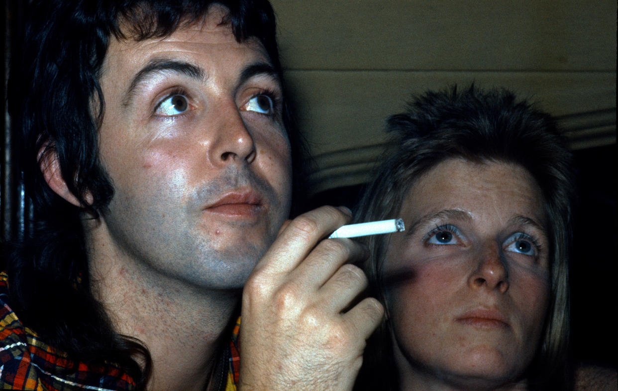 OXFORD, UNITED KINGDOM - JANUARY 01:  Paul McCartney smokes a cigarette and cuddles with wife Linda McCartney at a party in 1972 in Oxford, England. on January 01, 1972 in Oxford, England. (Photo by Anwar Hussein/Getty Images)