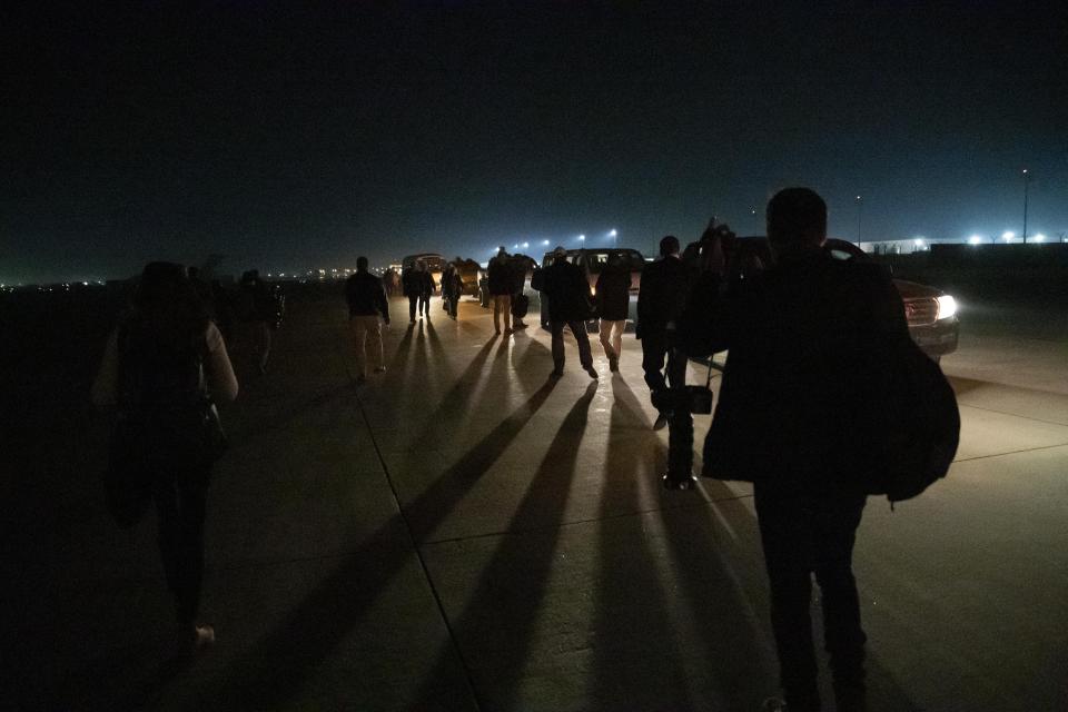 White House staff and press corps walk to waiting van during a surprise Thanksgiving Day visit to the troops by President Donald Trump, Thursday, Nov. 28, 2019, at Bagram Air Field, Afghanistan. (AP Photo/Alex Brandon)