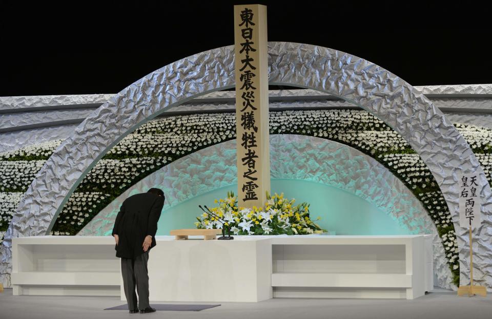 Japan's Prime Minister Shinzo Abe bows in front of the altar for the victims of the March 11, 2011 earthquake and tsunami at the national memorial service in Tokyo March 11, 2014. (REUTERS/Franck Robichon/Pool)