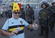 Soccer Football - World Cup - Third Place Play Off - Belgium v England - Saint Petersburg Stadium, Saint Petersburg, Russia - July 14, 2018. A supporter of Belgium poses for a picture as riot policemen stand guard after the match. REUTERS/Sergey Konkov