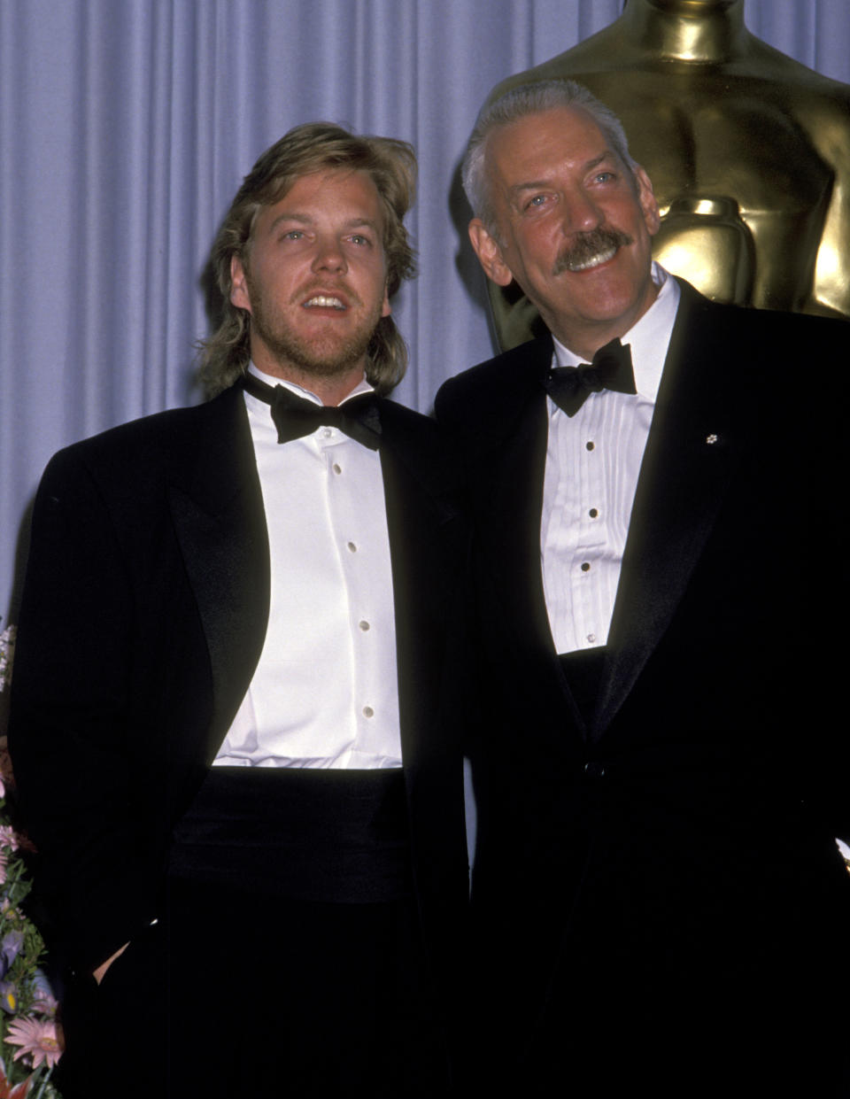 Kiefer Sutherland and Donald Sutherland, wearing tuxedos, standing together at the Oscars