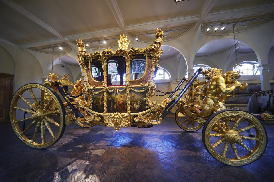 The Gold State Coach on display at the Royal Mews in Buckingham Palace, London, Tuesday April 4, 2023, in which King Charles III and the Queen Consort will return in to Buckingham Palace after the coronation on May 6. King Charles III is taking a short cut and smoother ride to Westminster Abbey, trimming the procession route his mother took in 1953 as he aims for a more modest coronation that will include some modern touches, Buckingham Palace said Sunday April 9, 2023. (Yui Mok/PA via AP)