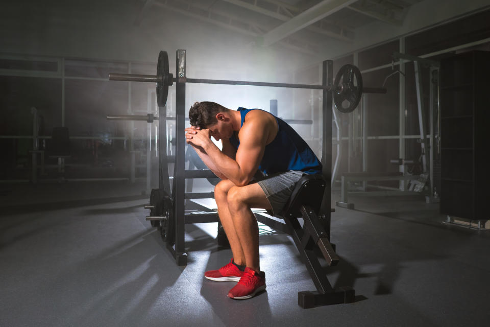 A distressed man sitting in a gym