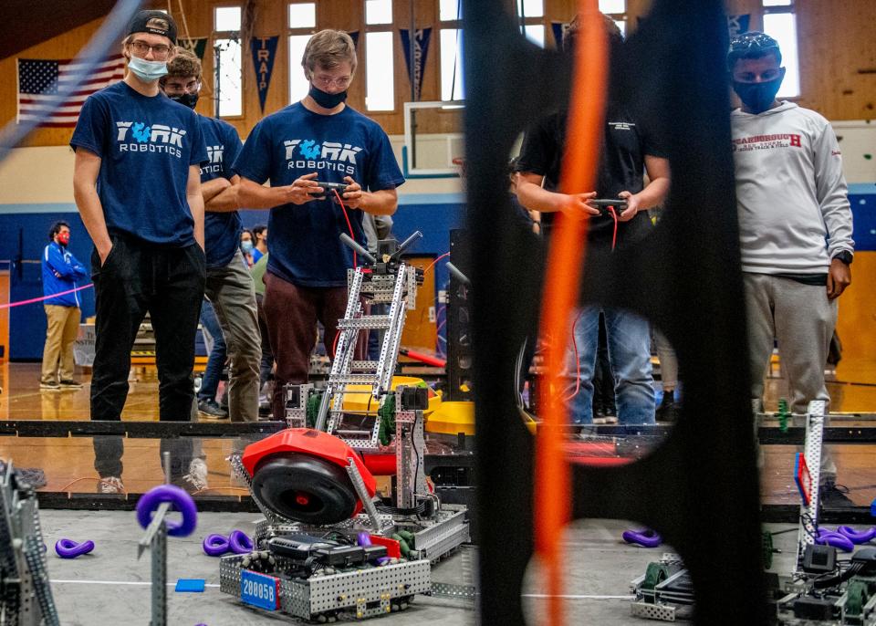 From left to right, teammates Cam Dalton, 17, Hunter Pruett, 17,  and Ben Boksanski, 18, compete in a qualifying match at the VEX Robotics Tournament hosted at York High School on Saturday, Nov. 13, 2021. The matches occur on a 12-by-12-foot field, with teams accumulating points by relocating towers and collecting purple rings to place on towers.