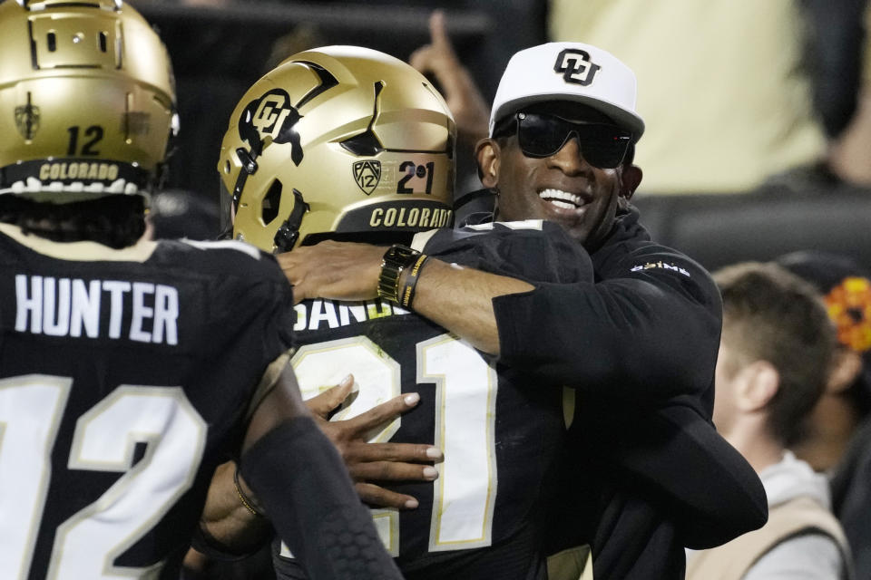 Colorado head coach Deion Sanders, right, hugs his son, safety Shilo Sanders, after he returned an interception for a touchdown against Colorado State Saturday, Sept. 16, 2023, in Boulder, Colo. (AP Photo/David Zalubowski)