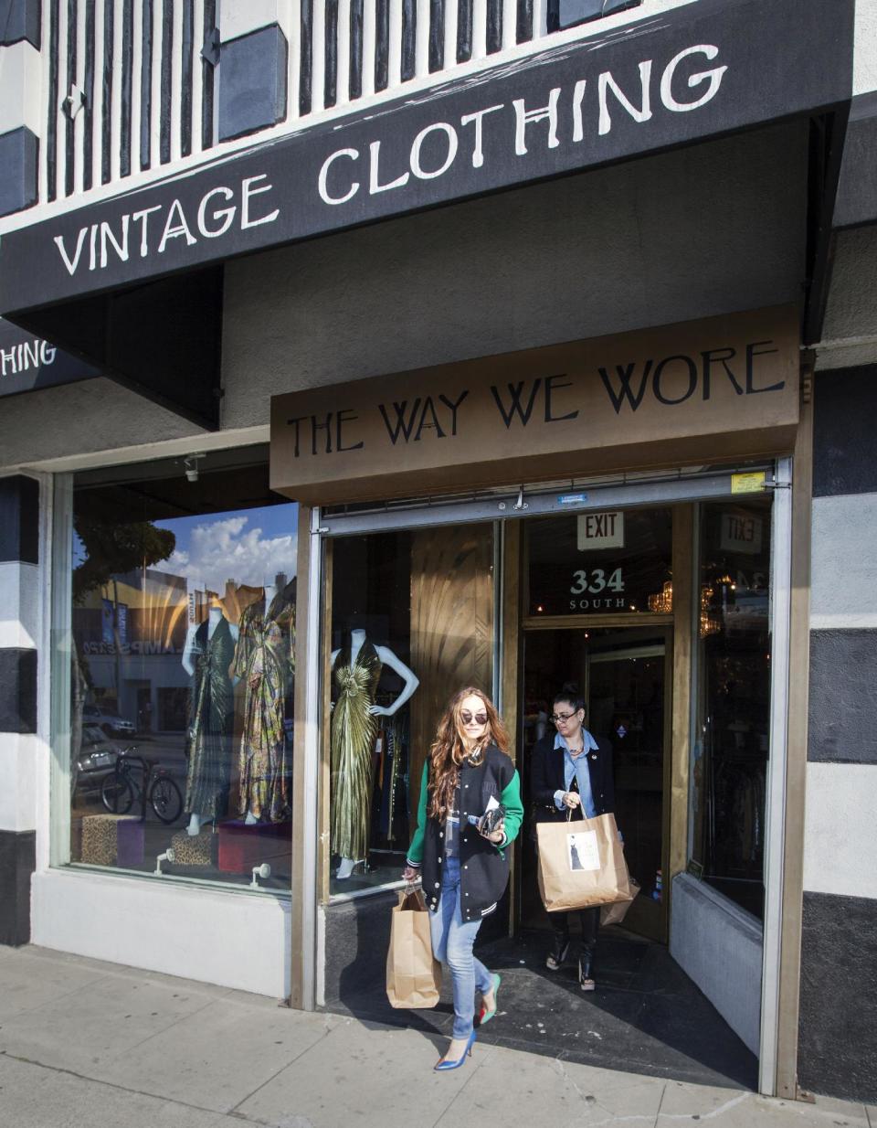 In this photo taken Thursday, Feb. 21, 2013, interior and fashion designer, Kelly Wearstler, left, is helped by consultant Sarah Bergman, after shopping for vintage designs "The Way We Wore," a Hollywood high-end vintage store owned by Doris Raymond in the La Brea District of Los Angeles. Raymond's vintage clothing and accessories store is featured in the reality TV series, "L.A. Frock Stars," which debuts March 7, 2013 on the Smithsonian Channel. (AP Photo/Damian Dovarganes)