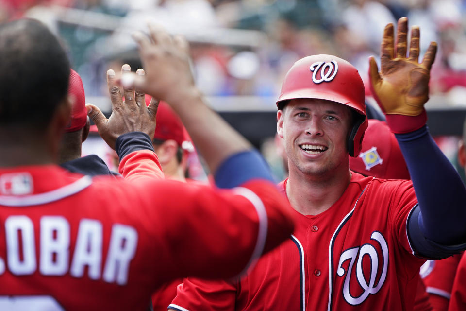 Washington Nationals' Riley Adams, right, is congratulated in the dugout after hitting a home run in the third inning of a spring training baseball game against the St. Louis Cardinals, Friday, March 25, 2022, in Jupiter, Fla. (AP Photo/Sue Ogrocki)