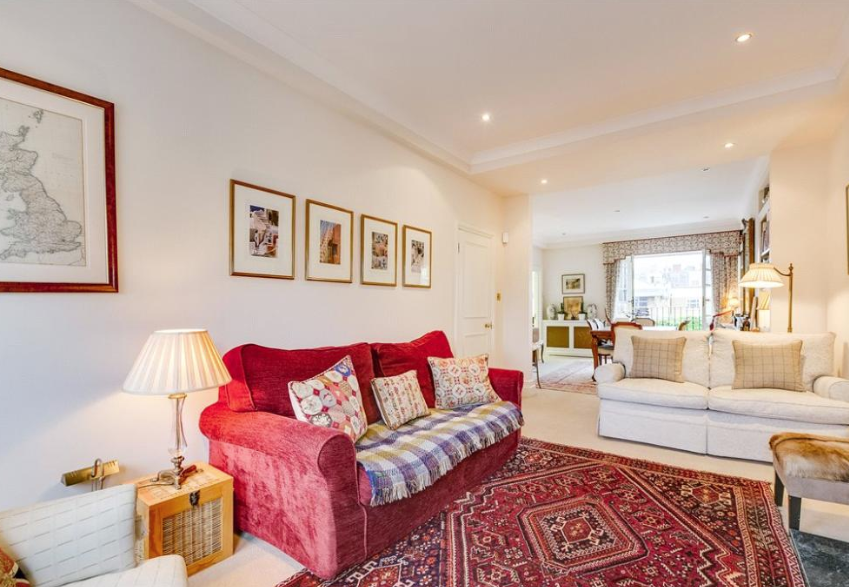 Red sofas and printed rugs add a pop of colour to the reception room (Right Move)