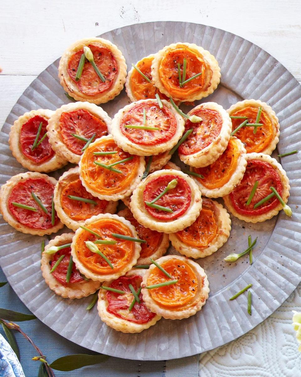 tomato manchego tartlets arranged on a metal serving plate