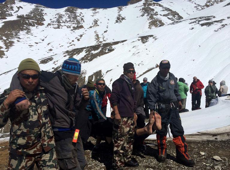 A survivor injured in a snowstorm is carried on a stretcher by Nepal Army personnel in the Manang district along the Annapurna circuit trek, on October 17, 2014