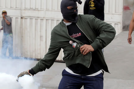 A demonstrator throws a tear gas canister to the police, during a protest against the re-election of Honduras' President Juan Orlando Hernandez in Tegucigalpa, Honduras January 20, 2018. REUTERS/Jorge Cabrera