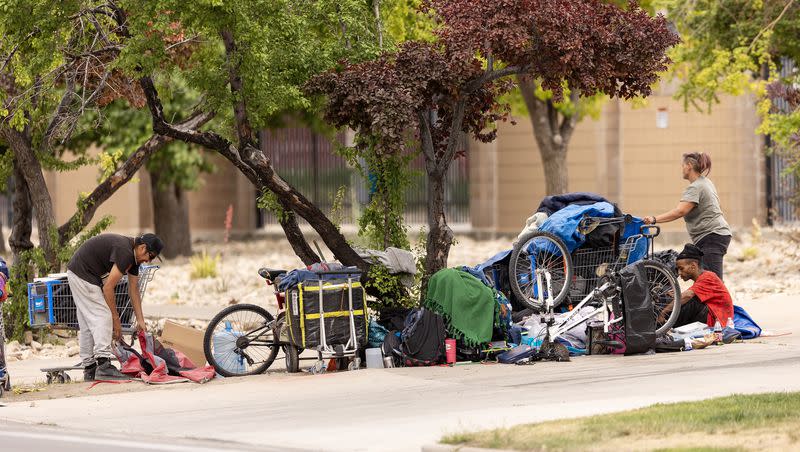 Homeless people sit or walk around small campsites in Salt Lake City on Wednesday, June 28, 2023.