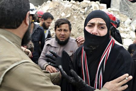 A woman reacts while civil defence members carry her dead child after what activists said was shelling by warplanes loyal to Syria's president Bashar Al-Assad in Aleppo's rebel-controlled Bab Al-Nairab district April 12, 2015. REUTERS/Abdalrhman Ismail