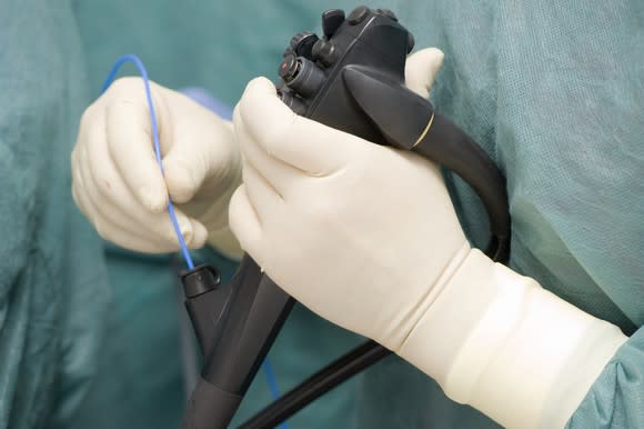 Gloved hands operate an endoscope