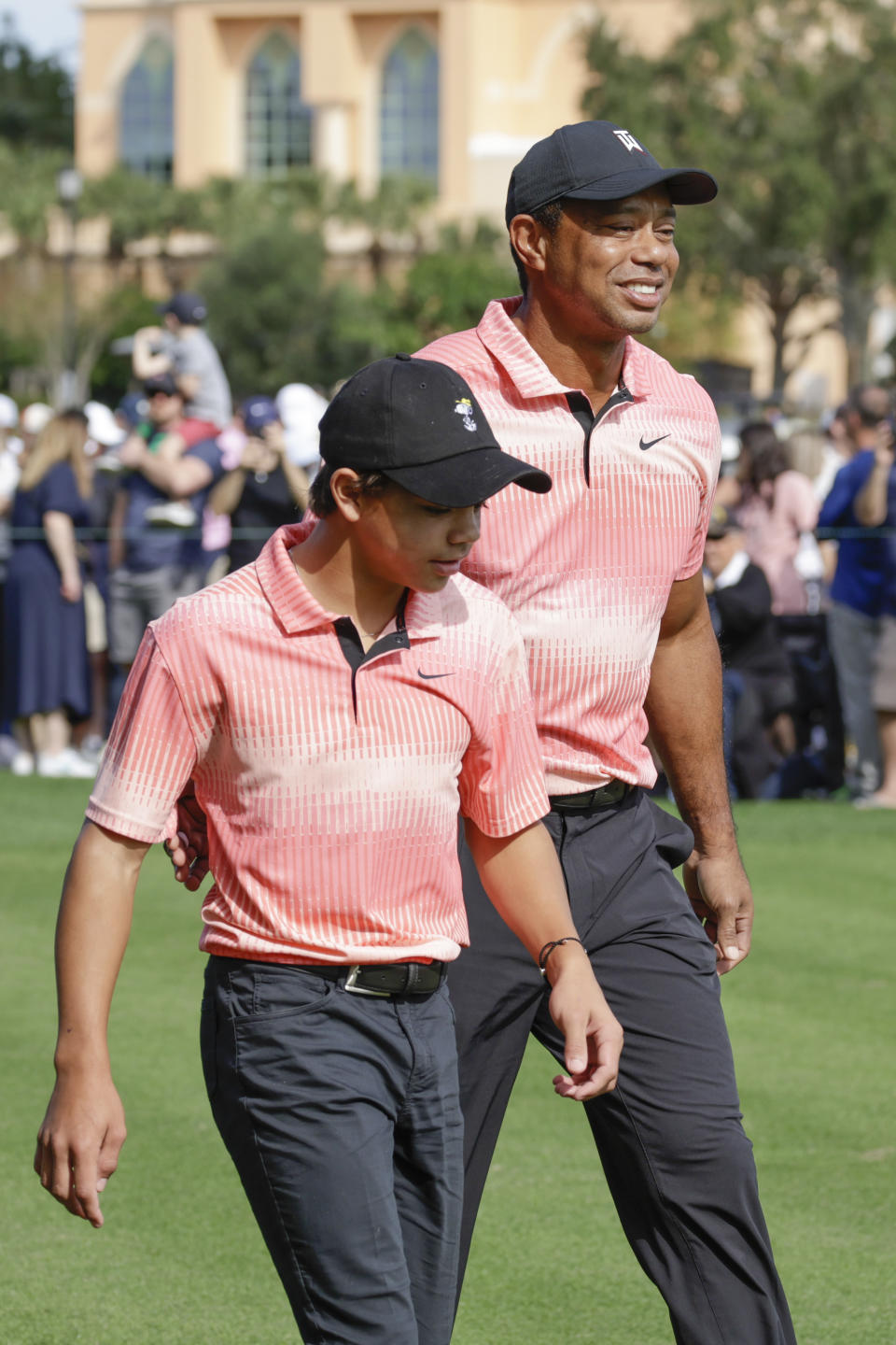 Tiger Woods and his son Charlie Woods walk down the fairway of the first hole during the first round of the PNC Championship golf tournament Saturday, Dec. 17, 2022, in Orlando, Fla. (AP Photo/Kevin Kolczynski)