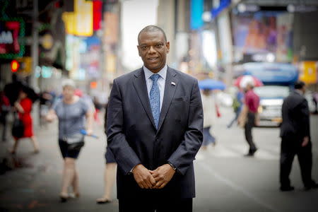 Ronald Long, director of Regulatory Affairs and Elder Client Initiatives for Wells Fargo Advisors, poses in New York's Times Square June 18, 2015. REUTERS/Brendan McDermid