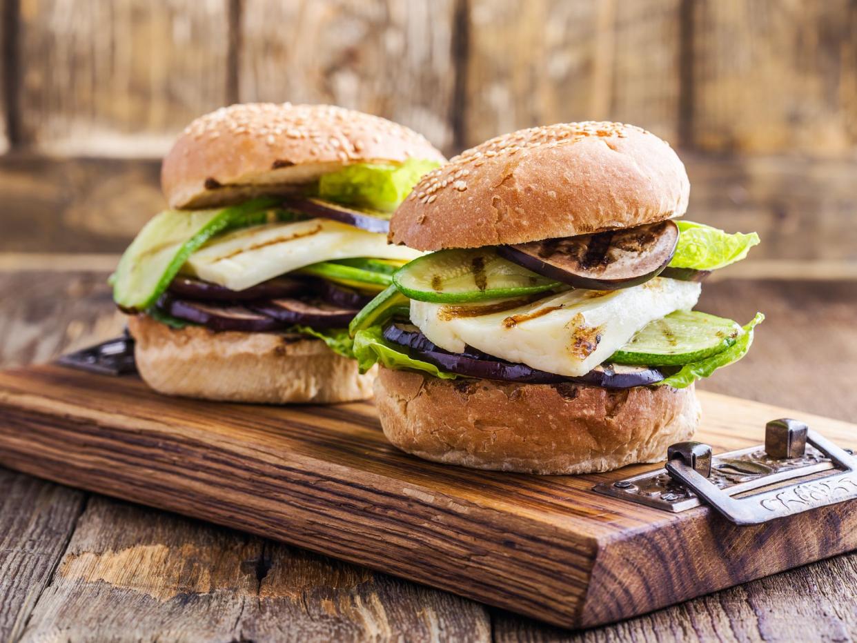 Grilled vegetable and haloumi burger with romaine lettuce on wooden table