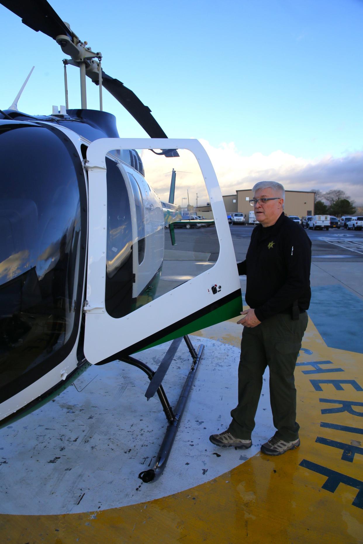 Sgt. Gary Mauldin, the chief pilot for the San Juan County Sheriff's Office, opens the door of the agency's new Bell 505 helicopter outside the sheriff's office headquarters in Aztec on Thursday, Dec. 14.