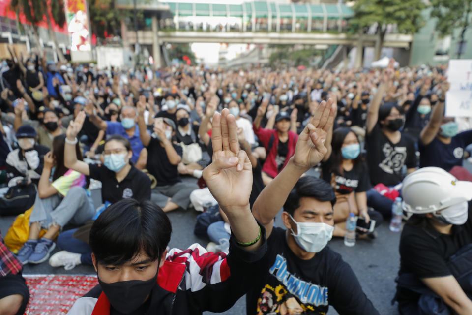Pro-democracy protesters flash the three-finger protest salute during an anti-government rally at a major intersection in Bangkok, Thailand, Wednesday, Nov. 18, 2020. Police in Thailand's capital braced for possible trouble Wednesday, a day after a protest outside Parliament by pro-democracy demonstrators was marred by violence that left dozens of people injured. (AP Photo/Sakchai Lalit)