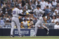 Colorado Rockies' Ryan McMahon, right, is congratulated by third base coach Stu Cole after hitting a grand slam against the San Diego Padres during the first inning of a baseball game Friday, July 30, 2021, in San Diego. (AP Photo/Derrick Tuskan)