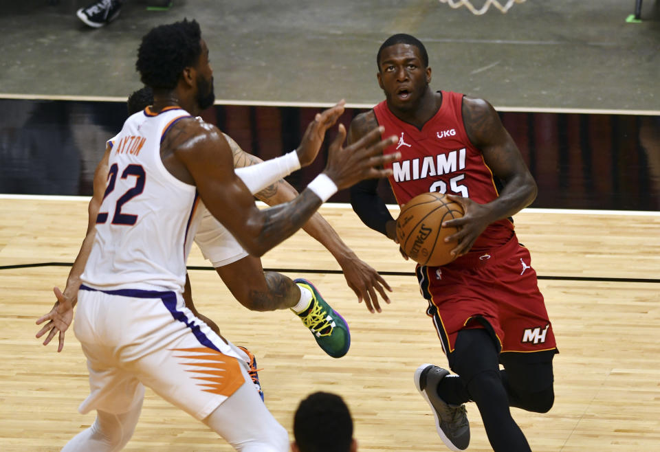 Miami Heat guard Kendrick Nunn (25) drives to the basket as Phoenix Suns center Deandre Ayton (22) defends during the first half of an NBA basketball game Tuesday, March 23, 2021, in Miami. (AP Photo/Jim Rassol)