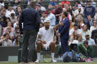 Australia's Nick Kyrgios talks to an official during a third round men's singles match against Greece's Stefanos Tsitsipas on day six of the Wimbledon tennis championships in London, Saturday, July 2, 2022. (AP Photo/Kirsty Wigglesworth)