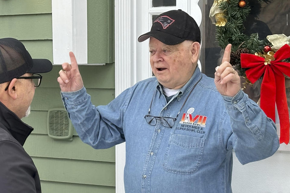 Don Crisman speaks with Verizon’s Joe Russo who surprised Crisman with a pair of Super Bowl tickets, at his home, Thursday, Jan. 18, 2024, in Kennebunk, Maine. Crisman is one of the very few people who has attended every Super Bowl. This year will be his 58th trip to the NFL's championship game. (AP Photo/David Sharp)