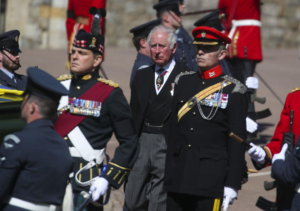 Prince Charles, centre, walks in the procession to St George's Chapel, Windsor Castle, Windsor, England, Saturday April 17, 2021, during the funeral of Britain's Prince Philip. Prince Philip died April 9 at the age of 99 after 73 years of marriage to Britain's Queen Elizabeth II. (Steve Parsons/Pool via AP)